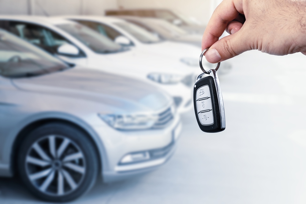 Man’s hand holding car key.Automobile rent or leasing concept.